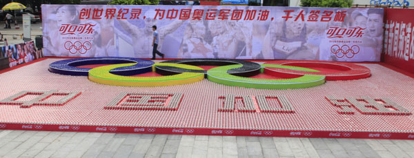 Beverage bottle and cans are arranged to make the famous five Olympic rings and four Chinese characters in Haikou, South China’s Hainan province, July 28, 2012. The rings cover about 61 square meters with more than 10,000 plastic bottles. The characters read “Come on China” to wish the Chinese Olympic team good luck. Thirst for Olympic success