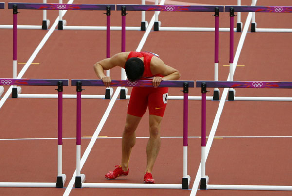 China's Liu Xiang kisses the last hurdle in his lane after crashing into the first hurdle and failing to finish his men's 110m hurdles round 1 heat at the London 2012 Olympic Games at the Olympic Stadium August 7, 2012. Liu hit by two-time injury-worry before London Olympics