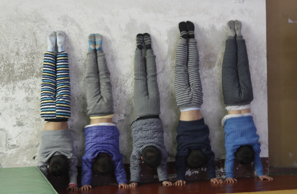 Children practice doing handstands at the Li Xiaoshuang Gymnastics School in Xiantao, Central China's Hubei province. Zhu Liudi / for China Daily Safety net for young gymnasts