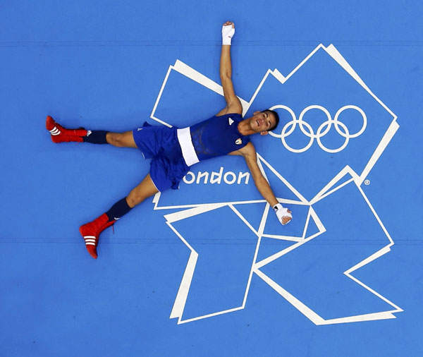 Cuba's Robeisy Ramirez Carrazana lays on the canvas after he was declared the winner over Mongolia's Tugstsogt Nyambayar following their Men's Fly (52kg) gold medal boxing match at the London Olympics August 12, 2012. Cuban boxer wins boxing men's 52kg gold medal