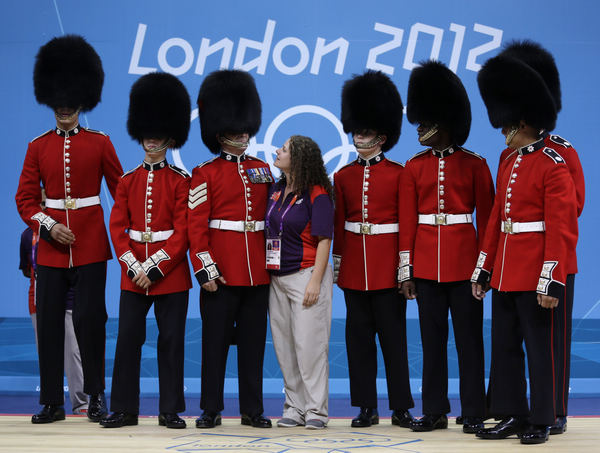 British volunteer Eloise Paterson (center) poses for a photo with members of the Coldstream Guards regiment, the oldest regiment in the British Army. Mike Groll / Associated Press Volunteers find the world in their grasp