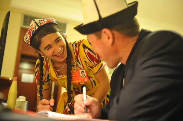 Rehangul Yimir, a 24-year-old NPC deputy from the Xinjiang Uygur autonomous region, talks with a colleague about the motion she will present at the NPC session which begins on Tuesday. Newcomers get chance to shine under NPC spotlight
