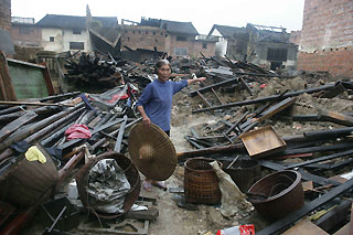 An old woman points at the wreckage left by tropical storm Kaemi yesterday at Gantang Village in Central China's Hunan Province.