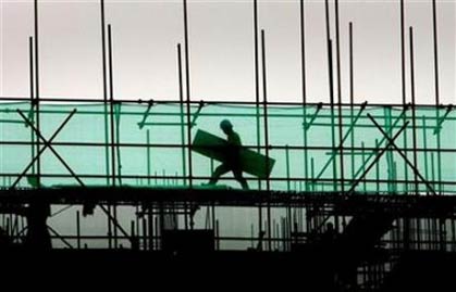 A laborer works on scaffoldings at a construction site in Nanjing, China, July 11, 2006.