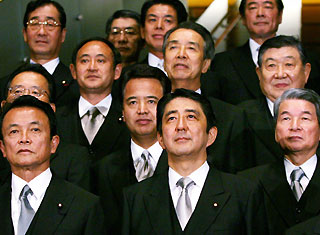 Newly-elected Japanese Prime Minister Shinzo Abe (C) poses with his Foreign Minister Taro Aso (L) and other cabinet members during an official group photo at the premier's official residence in Tokyo September 26, 2006.