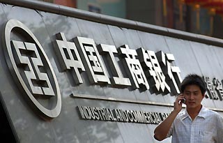 A man walks past a logo of the Industrial & Commercial Bank of China (ICBC) in front of its local branch in Hefei, east China's Anhui province October 16, 2006. ICBC, the country's biggest bank, priced its A-share initial public offering at a range of 2.60-3.12 yuan ($0.33-0.39) per share, it said on Monday.