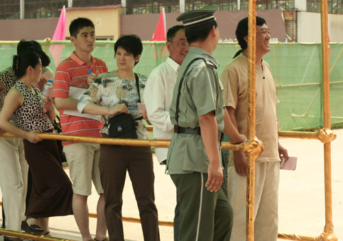 A security man talks with residents at the venue for a vote on demolishment and reconstruction of old buildings in Juixiaqiao Sub-district in Beijing, June 9, 2007. Local government and the real estate developer jointly organize the vote on Saturday to see if majority residents of over 5000 families accept the new compensation policy after failed attempts to reach an agreement through other ways. Both notary officials and supervisors are invited to monitor the vote that runs from 9 a.m. to 9 p.m. at six ballot booths. [Sun Yuqing/www.labontemusic.com]