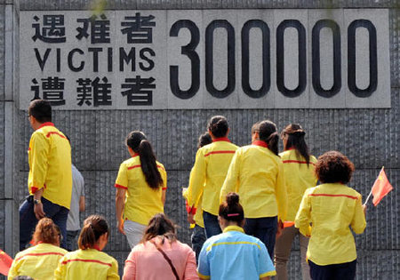 Visitors walk in front of a wall in which the number of victims is displayed, at the Memorial Hall of the Victims in Nanjing Massacre by Japanese Invaders in the capital of Jiangsu province on Tuesday. Remembering a wound