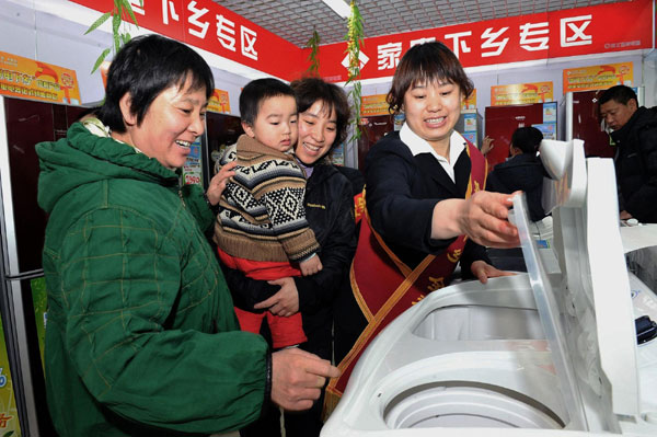 A saleswoman introduces washing machines to rural customers in Shunyi district, Beijing on March 12, 2010. China's rural achievements in the past decade