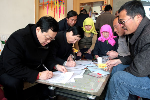 Bank clerks deal with a small loan application in a villager's home in Zhangye city, Gansu province on May 30, 2010. China's rural achievements in the past decade