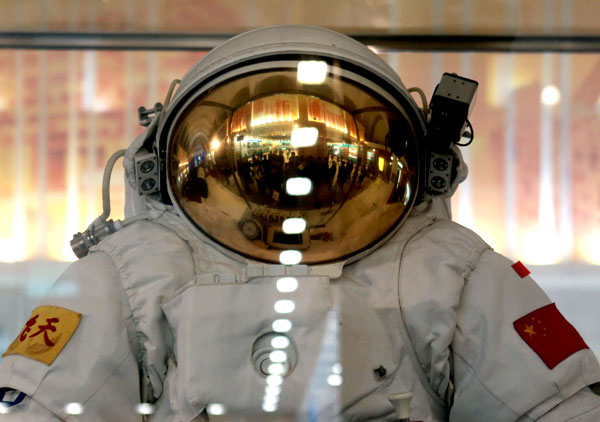 A group of visitors are reflected on a spacesuit helmet during an exhibition featuring China's achievements over the past decade at the Beijing Exhibition Center on Wednesday. Feng Yongbin / China Daily Overseas media view China's progress