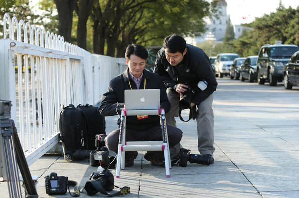 Photographers work during the coverage of the 18th National Congress of the Communist Party of China (CPC) at the Tian'anmen Square in Beijing, capital of China, Nov 8, 2012. Journalists cover opening ceremony of CPC congress