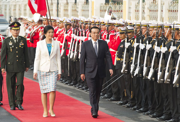 Premier Li Keqiang, center, attends a welcome ceremony held by Thai Prime Minister Yingluck Shinawatra upon his arrival at the Government House in Bangkok, Thailand, Oct 11, 2013. Yuan clearing bank in sight