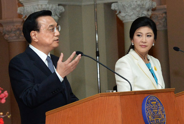 Premier Li Keqiang, left, and Thai Prime Minister Yingluck Shinawatra meet media after their meeting at Government House in Bangkok, Thailand, Oct 11, 2013. Yuan clearing bank in sight