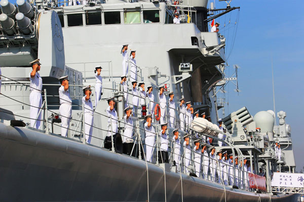 Soldiers of the North China Sea Fleet, one of three fleets of the People’s Liberation Army Navy, salute on the missile destroyer Qingdao before departure, in Qingdao, East China’s Shandong province, Aug 20, 2013. Chinese navy to visit US, New Zealand, Australia