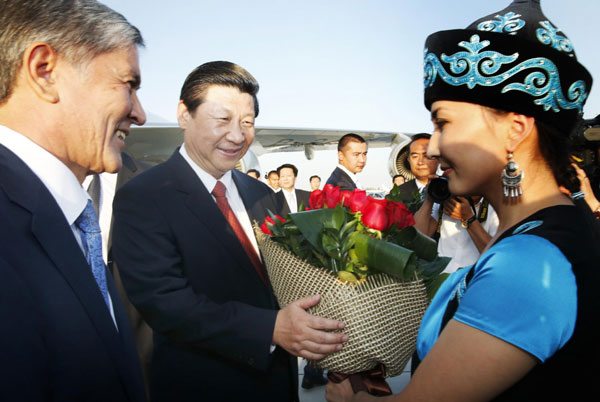 President Xi Jinping, center, is welcomed by his Kyrgyz counterpart Almazbek Atambaev (L) as he arrives at the airport in Bishkek, Kyrgyzstan, Sept 10, 2013. Xi in Kyrgyzstan for state visit, SCO summit