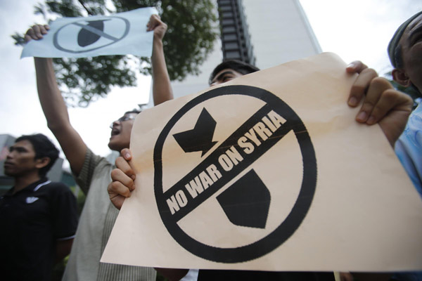 Demonstrators display placards during a protest against possible U.S. attacks on Syria, outside the U.S. embassy in Kuala Lumpur September 6, 2013. UN chief opposes militarization in Syria