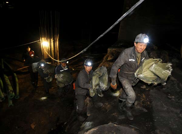 Rescuers carry equipment at the flooded Yuanbaowan Coal Mine in Shanyin county, Shuozhou city, North China’s Shanxi province, early on Saturday morning. YAN YAN / XINHUA Rescuers racing to find trapped miner