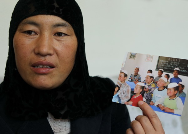 Ma Lan, who teaches at a community school in Gantugou, Dongxiang, shows a photo of her students when she started a school in her home village in 2003. School is where the home is
