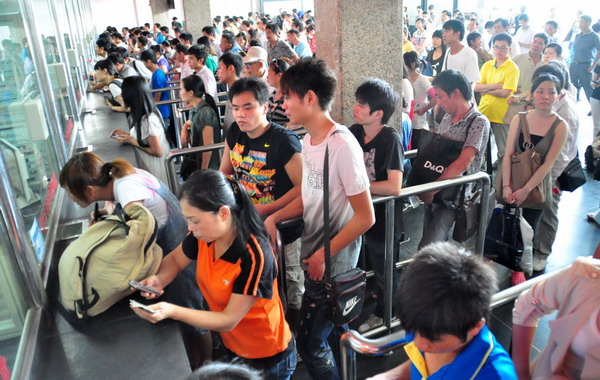 Passengers stand in line to buy train tickets at Nanning Railway Station in the Guangxi Zhuang autonomous region on Wednesday. Some turn to scalpers for tickets home
