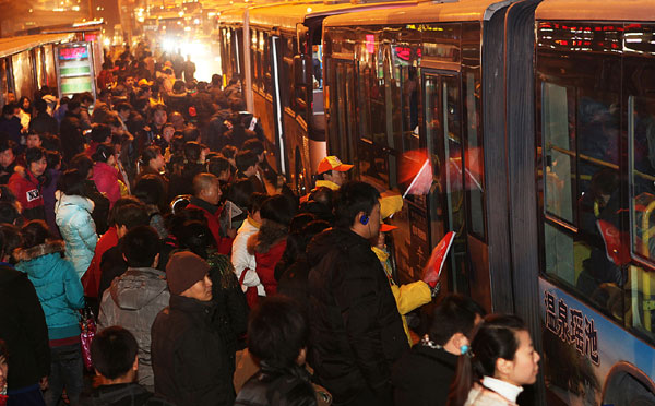 File photo taken on Dec 9, 2010 shows people queuing for taking buses at a bus station in Beijing. China to maintain family planning policy