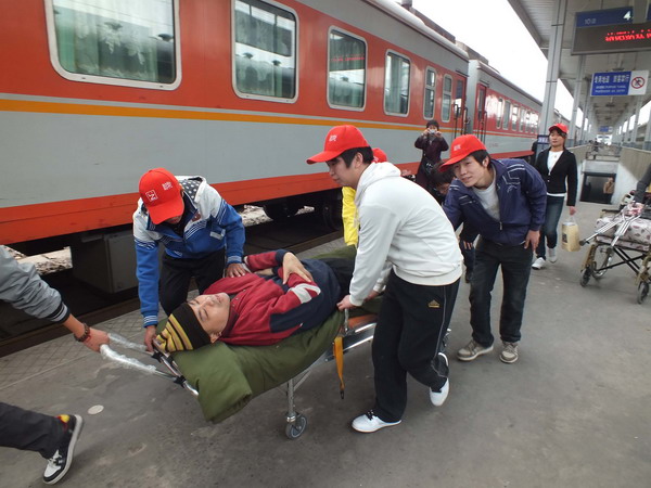 People help Zhang Dayong to board a train in Luoyang, Henan province, on Oct 26. Zhang, who suffers from rickets, launched a nationwide database for unidentified bodies. Guangzhou is his first stop. Bringing the dead back home