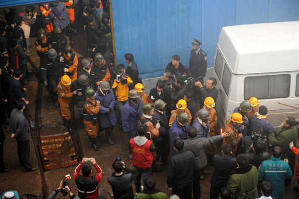 Miners with the help of rescuers walk out of the pit at a coalmine in Yima, Central China's Henan province, Nov 5, 2011, after a rock burst happened on Friday. Eight workers have been confirmed dead and 45 trapped miners have been found alive. As of 8 am on Nov 5, 37 miners have been safely lifted to the surface.[ 8 killed, 45 rescued in C China coal mine