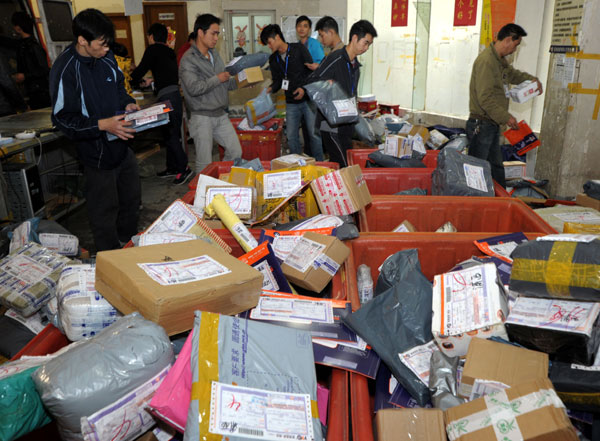 Workers at YTO Express, a Shanghai-based express mail service provider, sort a sudden increase in deliveries on Nov 11. Niu Yixin / for China Daily Singles' Day sales push couriers to the limit