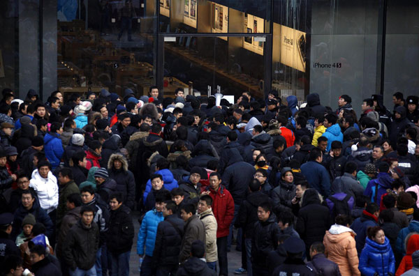 Police remove some people from the crowd outside an Apple store while they were waiting for it to open in the Beijing district of Sanlitun January 13, 2012. Apple suspends iPhone 4S sales in Beijing, Shanghai