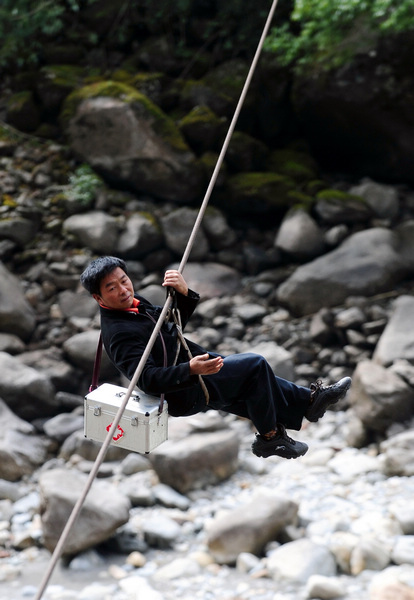 On his way to a patient's home last year, Deng Qiandui, a doctor, gets across the Nujiang River by moving on a ropeway in Lamadi village of the Nujiang Lisu autonomous prefecture in Yunnan province. Within the next three years, all 42 ropeways across the three main rivers in the prefecture will be replaced or reconstructed, local government officials said. Qin Qing / Xinhua Shaky crossings to get updated