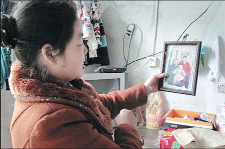Zhang Caiying, the eldest biological daughter of Lou Xiaoying, shows a photo of the last child Lou adopted. The 89-year-old Lou adopted 18 children. Yang Wanli / China Daily Babies find 'home' in her arms