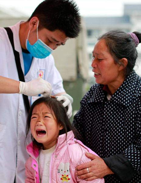 Seven-year-old Wang Yuntian is treated by doctor Chai Yuan for injuries suffered in Saturday's deadly earthquake in Longmen township, Sichuan province. Efforts in the quake zone have shifted to keeping survivors healthy. Feng Yongbin / China Daily Health new priority