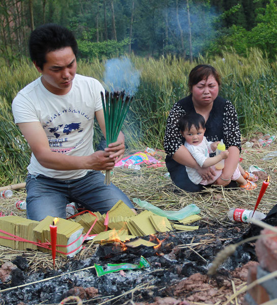 Shu Wei, his wife Yang Xiaoli and younger daughter mourn the family’s 5-year-old elder daughter who was killed in last Saturday’s earthquake in Lushan county, Sichuan province. CUI MENG / CHINA DAILY Baoxing gets back to business, but quake fears linger