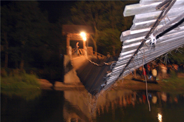 A suspension bridge overturns in Fenghuang county, a tourist town in Central China's Hunan province, May 1, 2013. Most tourists rescued after bridge overturns in C China