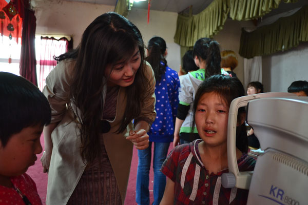 Yang Wei, manager of Jia Yue Eye Surgery Centre, is comforting a crying girl Vision of care for village children