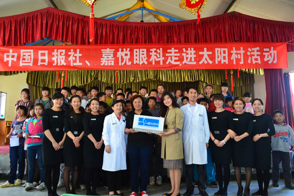 Zhang Shuqin, initiator of Sun Village, and Yang Wei, manager of Jia Yue Eye Surgery Centre, are holding a plate saying Medical Aid Object of Jia Yue Eye Surgery Centre when taking a group photo Vision of care for village children