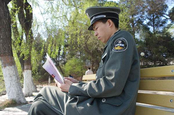 As a security guard at Peking University, Gan Xiangwei spends his spare time reading books. Photo provided to China Daily University doors open for its security guards