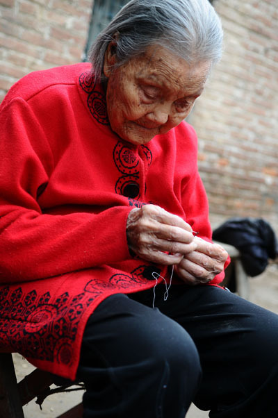 Wang Jingzhi can still thread a needle at 113 in Yanggu city, Liaocheng county, East China's Shandong province, May 27, 2013. Oldest centenarian in town celebrates 113th