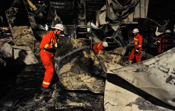Firefighters search for survivors at the burnt poultry slaughterhouse owned by the Jilin Baoyuanfeng Poultry Company, June 3, 2013. Poultry plant fire death toll rises to 120