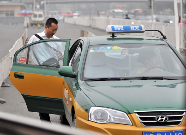 A man takes a taxi near Beijing Railway Station, June 6, 2013. Green light for Beijing cab fare hike