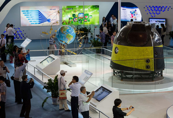 A Beidou Satellite Navigation System model (left) and the Shenzhou IX spaceship are displayed during the 16th China Beijing International High-Tech Expo on May 22, 2013. Beidou experienced past interference
