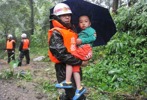 A child is evacuated from the landslide site in Zhongxing, a town in Dujiangyan, Sichuan province, on Wednesday. At least two people were killed. ZHANG LEI / FOR CHINA DAILY 12 confirmed dead in SW China landslide