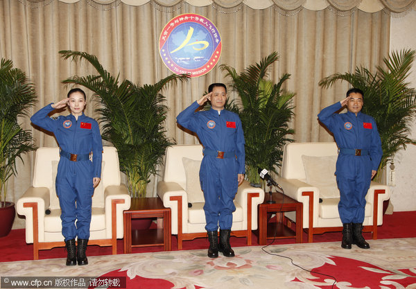 Shenzhou X astronauts Wang Yaping, Nie Haisheng and Zhang Xiaoguang salute at a news conference at Beijing Aerospace City on July 11, 2013, after they were released Thursday from their medical quarantine and given the medical all clear. Shenzhou X astronauts out of quarantine