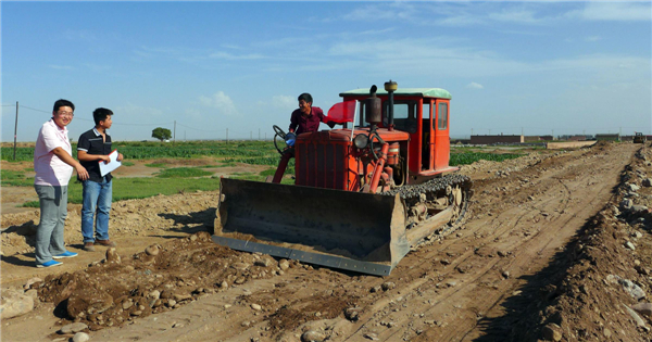 government officials from the local transportation department help guide farmers to pave the road with a tractor shovel N China farmers get help from govt officials