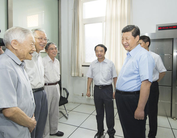 President Xi Jinping (R front), also general secretary of the Central Committee of the Communist Party of China (CPC) and chairman of the Central Military Commission (CMC), talks with academicians of the Chinese Academy of Sciences (CAS) who participated in the creation of the Beijing Electron Position Collider (BEPC) in Beijing, July 17, 2013. Scientists called to serve