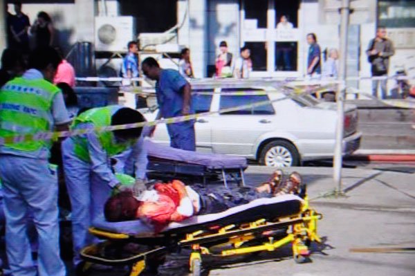 An injured man is treated outside the bakery in Beijing, July 24, 2013. 2 killed in Beijing bakery blast