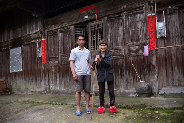 Jiang Jun and his mother Lv Xiuying in Gaozhai village, Huajiang Yao ethnic town of Xing’an county in Guangxi. Lost and found bomber brings explosive life changes