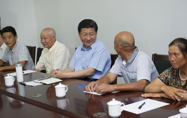 President Xi Jinping (C), who is also general secretary of the Communist Party of China (CPC) Central Committee, talks with villagers during a meeting at Dongshan village of Changgang township in E'zhou city, Central China's Hubei province, July 22, 2013. Xi urges deepening reform, opening up