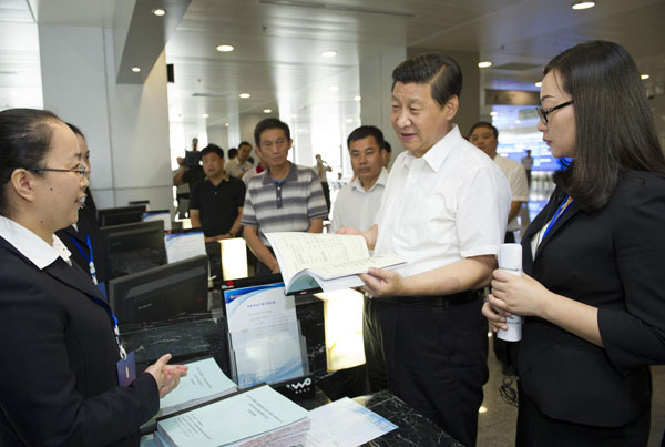 President Xi Jinping (2nd R), who is also general secretary of the Communist Party of China (CPC) Central Committee, talks with staff members and farmer customers at a rural equity transaction house in Wuhan, the capital of central China's Hubei Province, July 22, 2013. Xi urges deepening reform, opening up