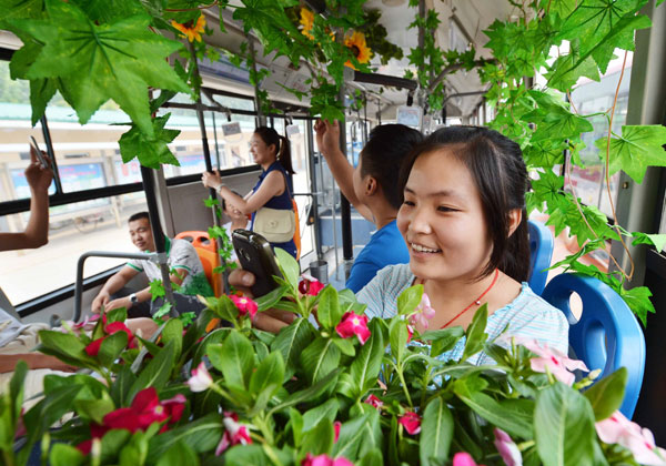 A passenger enjoys the beautiful flowers on the No 58 Bus in Shijiazhuang, capital province of Hebei on Aug 13. Plants put on bus to cool passengers' spirits